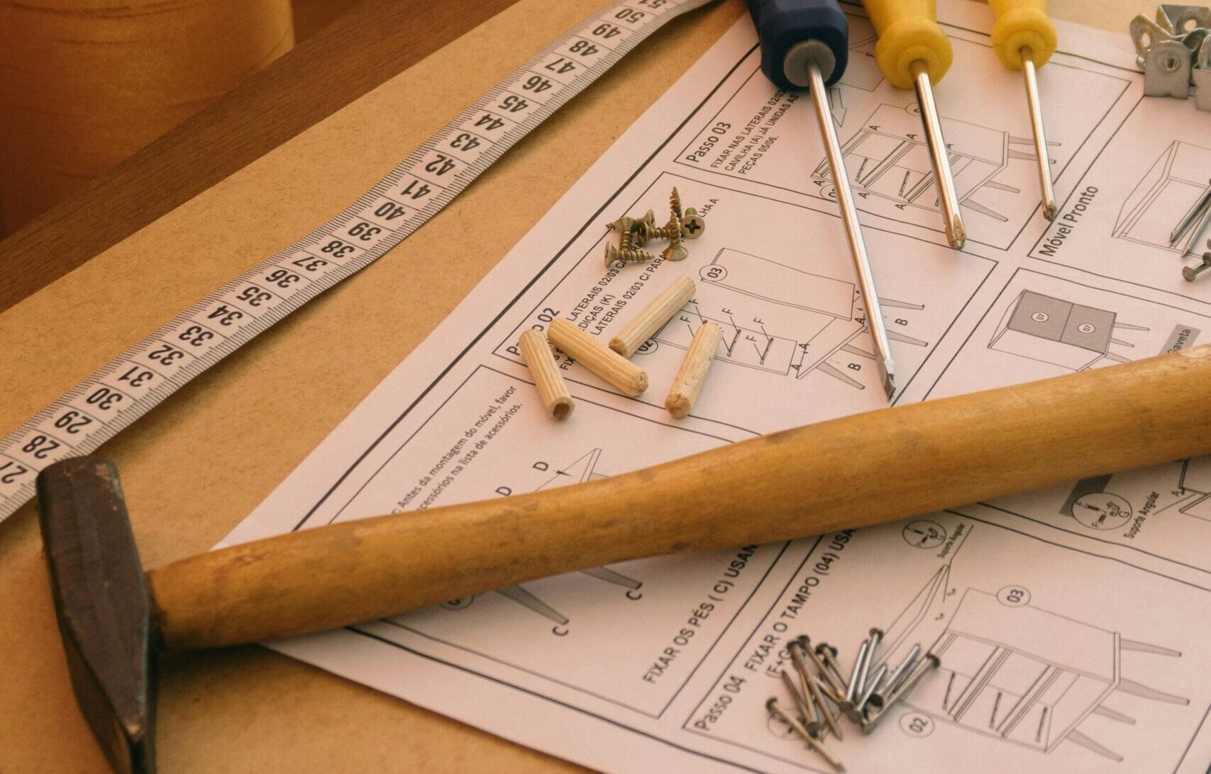 A set of tools and instructions for assembling DIY furniture, including a hammer and screwdrivers.
