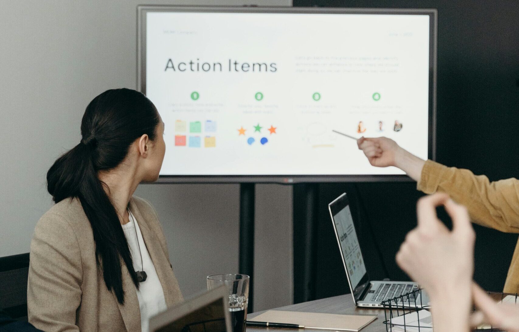 Colleagues discussing a presentation of action items in an office setting.